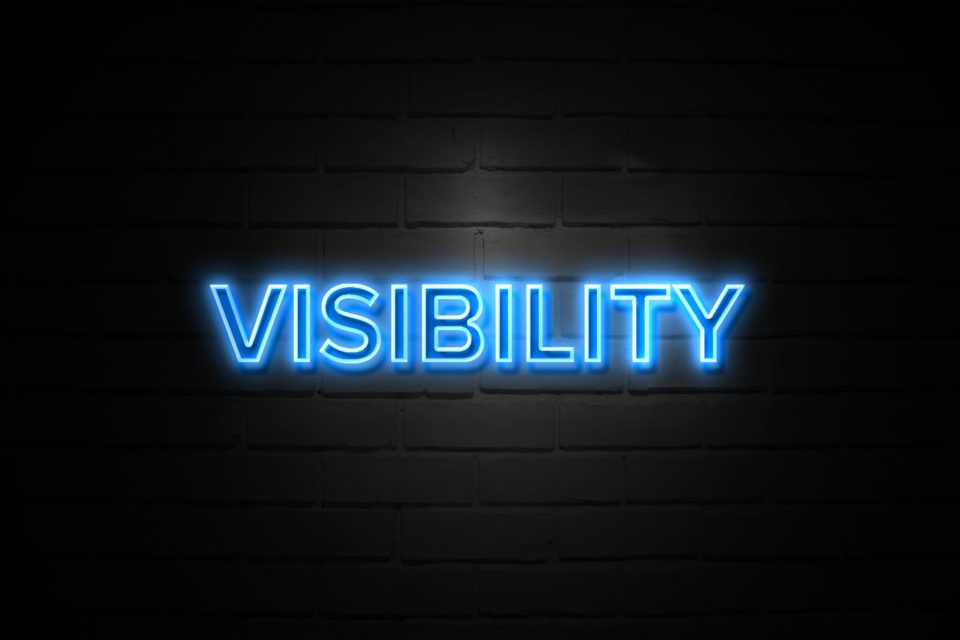 The word "Visibility" lit up in blue neon