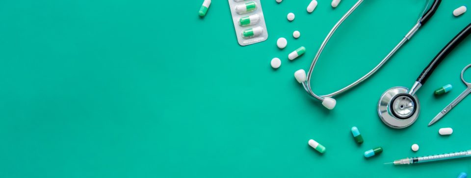 Medical equipment and pills on a green background