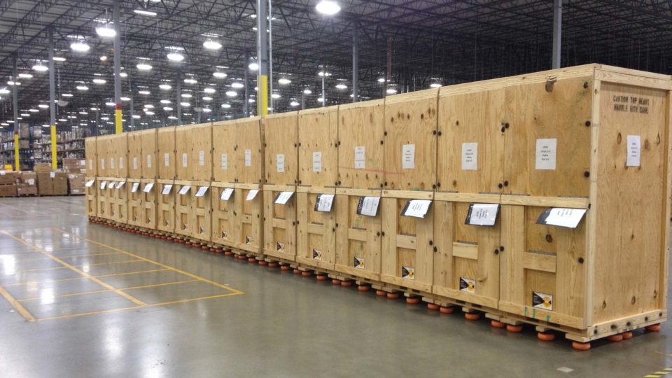 Custom wooden crates built by Flat World's crating team are lined up in a warehouse