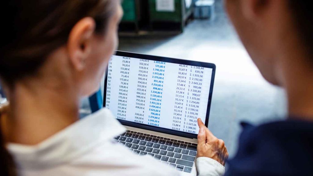 Two people look at a freight claims audit on a laptop