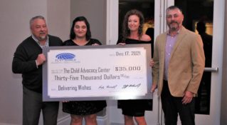 The Flat World team presents a check to the Child Advocacy Center
