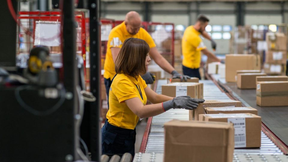 Warehouse employees package parcels being sent out