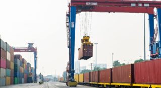 A shipping container moving via intermodal shipping is moved onto a train