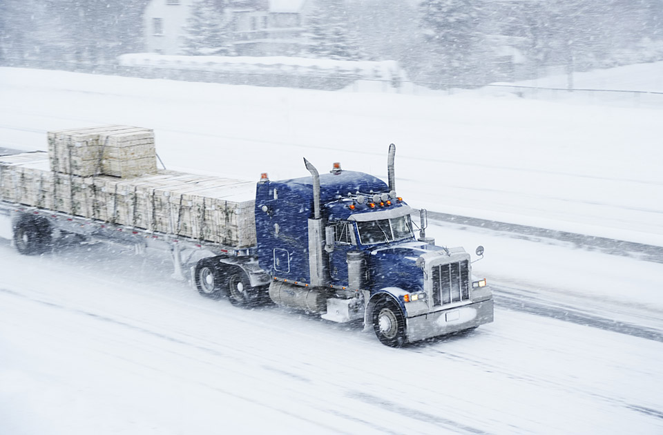 A truck transports a full truckload shipment in a winter storm