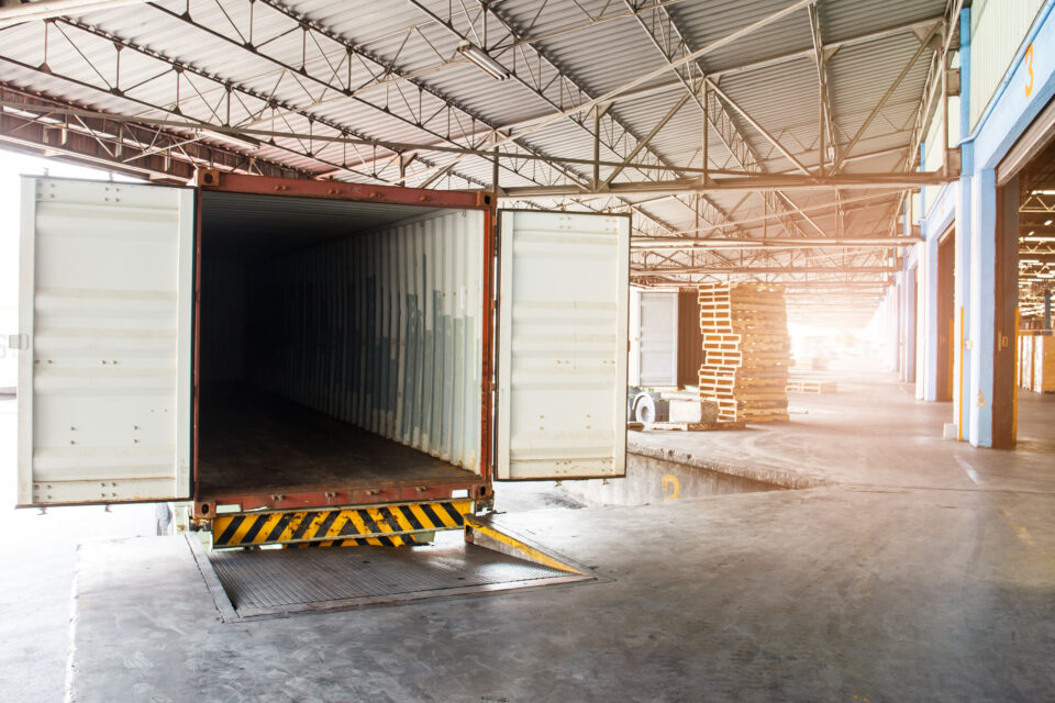 Empty heavy container truck parked or docked at warehouse loading area.