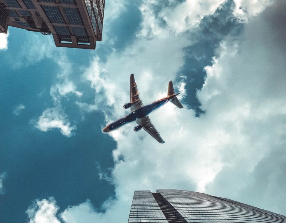 plane in the sky above buildings